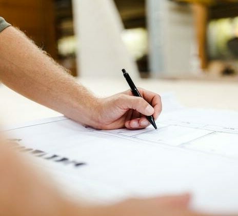 Hand drafting details on a set of construction drawings